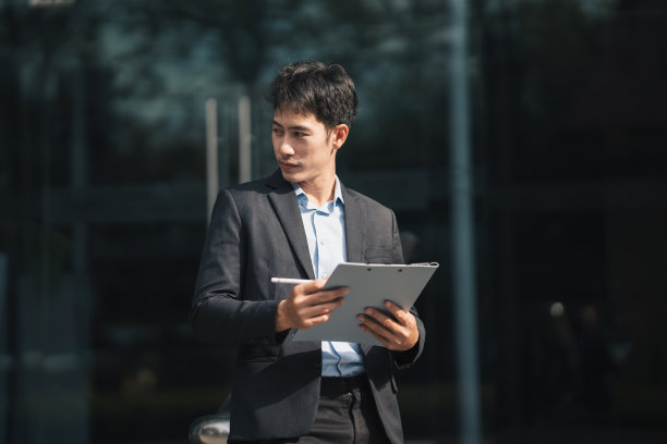 年轻英俊的经理坐在户外的楼梯上，用笔记本电脑工作，工作生活平衡的概念。图片下载