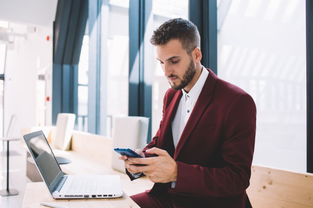 商人在联合办公空间使用智能手机图片下载