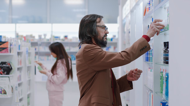 一名男子在药店查看卫生用品货架图片下载