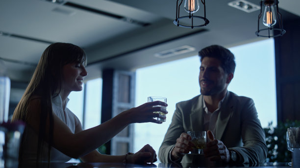 同事们在酒店酒廊碰杯。合伙人在高档餐厅欢呼图片下载