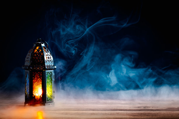 晚上，阿拉伯灯笼在桌子上点着烟。开斋节、斋月、伊斯兰节日贺卡设计。图片下载