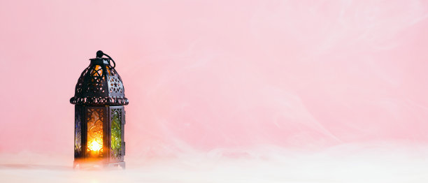 斋月Kareem灯笼与发光的蜡烛在粉红色背景与烟。开斋节贺卡穆巴拉克，穆斯林斋月卡里姆旗帜模板。图片下载