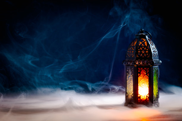 斋月卡里姆贺卡设计。阿拉伯灯笼在晚上发光的桌子上有烟。开斋节，穆斯林的圣月概念。图片下载
