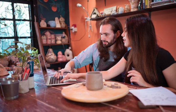 两个拥有陶器生意的年轻企业家。我们正在讨论客户想要成型的容器。用来装饰房子图片下载