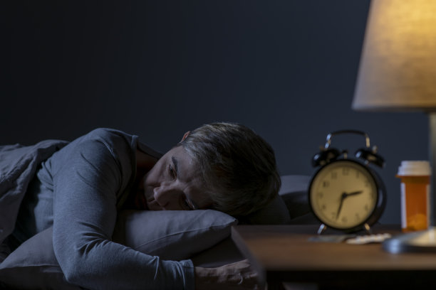 抑郁的老年妇女因失眠躺在床上无法入睡图片下载