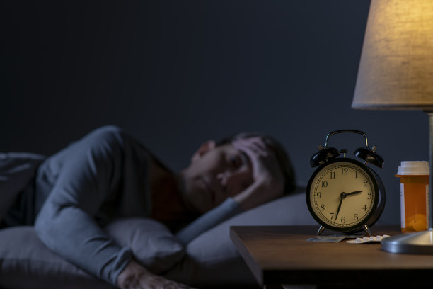 抑郁的老年妇女因失眠躺在床上无法入睡图片下载