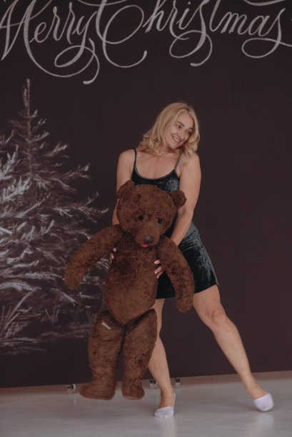 这个女孩手里拿着一只大的交易熊。图片下载