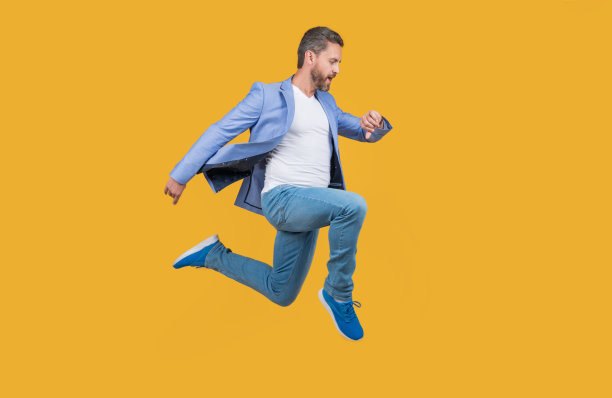 黄色背景下的人被隔离开来。男人赶时间。期限的概念图片下载