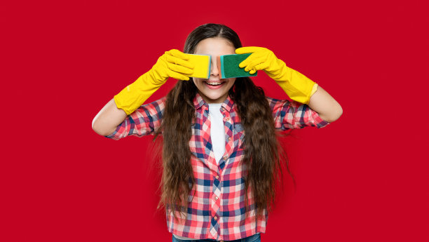 女孩清洁工的照片，微笑着用海绵做家务。女孩清洁工做家务图片下载