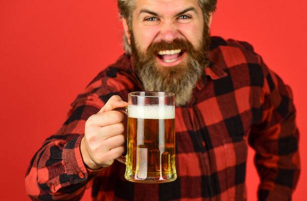 享受啤酒。自信的调酒师。酒吧里的酒保。在酒吧休息。欢呼。体育酒吧。尝试一种新啤酒。野蛮的潮人喝啤酒。成熟的大胡子男子手持啤酒杯。一杯酒精饮料图片下载