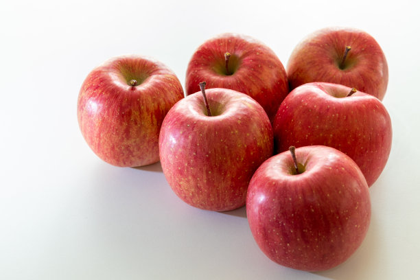 白色的桌子上有许多红苹果图片下载