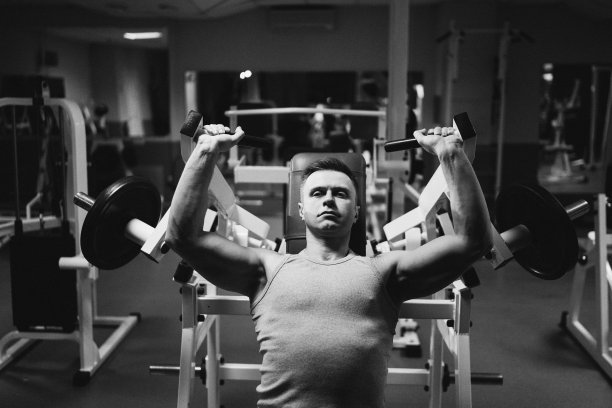 运动员在卧推上用哑铃锻炼胸部。强壮、英俊、健康的男人在健身房锻炼。图片下载