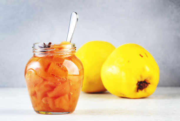 在玻璃罐中放入榅桲酱或配上肉桂和八角，放在灰色的餐桌背景上，复制空间图片下载