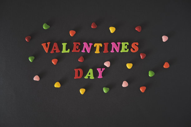 情人节由黑色背景的彩色字母组成。图片下载