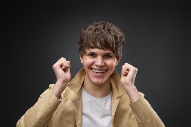 非常兴奋的年轻人挥舞着拳头，展示胜利的姿态图片下载