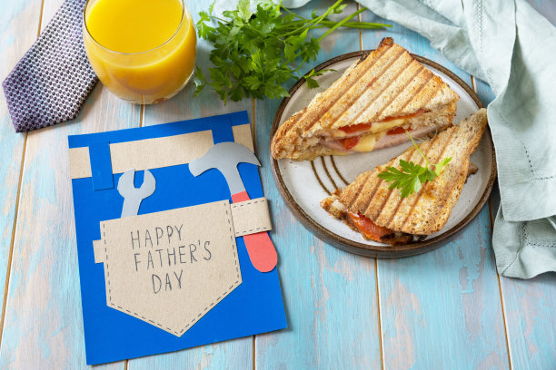 庆祝父亲节。早餐父亲节贺卡和木制桌子上的自制培根三明治。图片下载