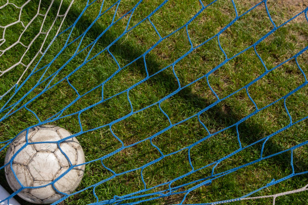 旧足球网背景上的草地足球场。夏日的晴天图片下载