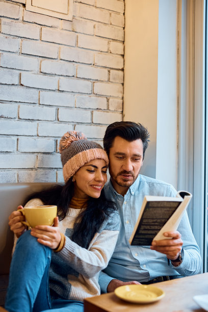 一对幸福的夫妇在咖啡馆里一起看书。图片下载