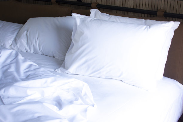 床上有一个白色的枕头。酒店里有床上用品图片下载