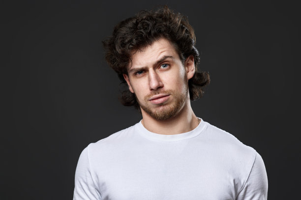 怀疑和紧张的人在白色t恤上的深灰色背景图片下载