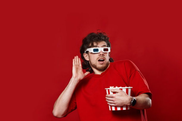 一个戴着3d眼镜拿着爆米花的害怕男人图片下载