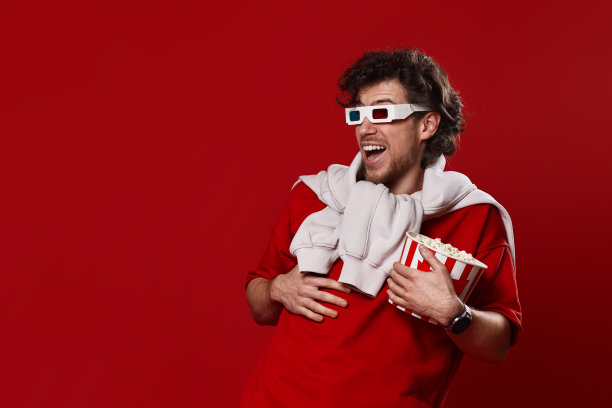 带着3d眼镜的笑男，t恤和一大桶爆米花图片下载