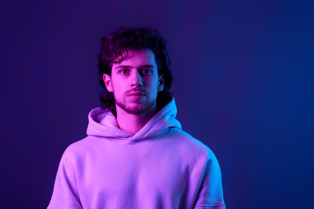 英俊的大胡子男子在运动衫上的蓝色背景。图片下载