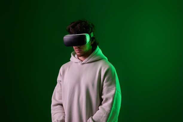 戴着vr眼镜、穿着运动衫的男子在蓝色背景上播放。图片下载