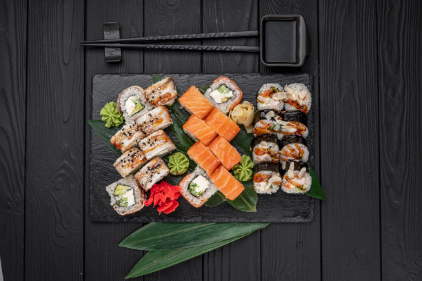 一整套亚洲食物。深色背景上的寿司和面包卷。图片下载
