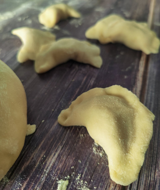 自制的土豆生饺子放在木桌上图片下载