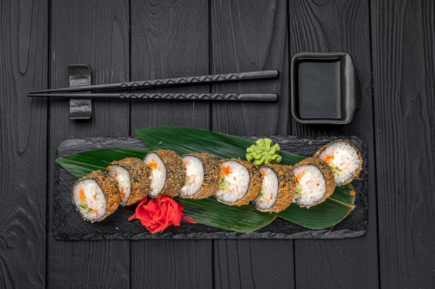 热腾腾的天妇罗卷配三文鱼和芝士，传统美味的新鲜寿司卷配黑色背景。图片下载