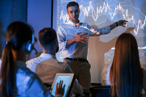 公司发展计划。证券交易公司办公室里，男领导通过投影仪向员工展示信息图片下载
