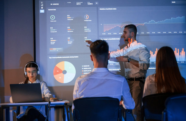 大师班。股票交易公司办公室里，男领导在向员工讲话，在投影仪上展示计划图片下载