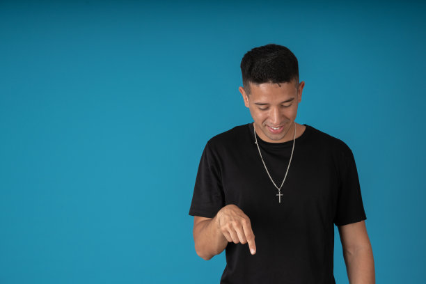 年轻的宗教人士摆姿势指着地板图片下载