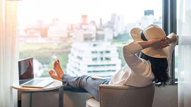 工作-生活平衡，生活质量，在家工作和旅行的概念与商务女性放松，放松，休息在酒店度假村，公寓，或公寓豪华客厅与笔记本电脑图片下载