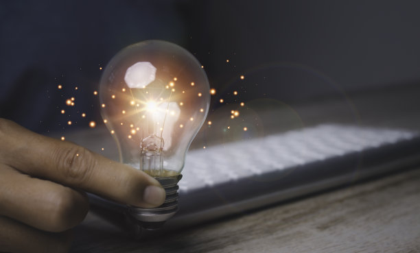 手持灯泡的商人灵感来自网络技术。图片下载