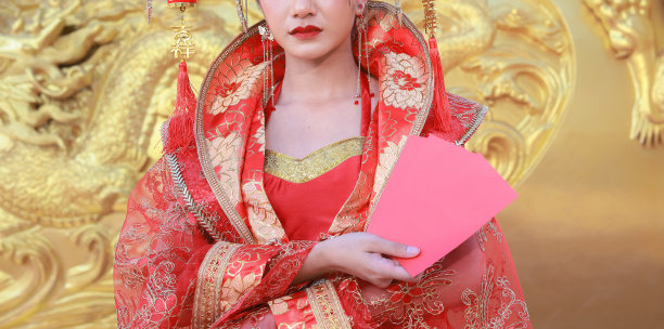 中国新年，身穿红色中式旗袍的年轻亚洲女性，手持红包图片下载