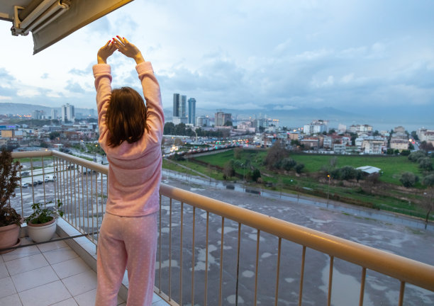 一名女子站在阳台上醒来后爬起来图片下载