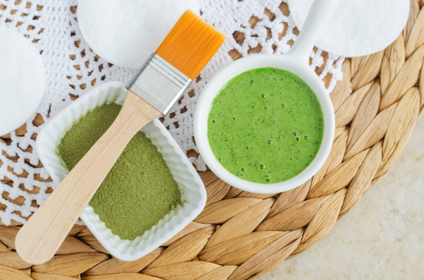 自制抹茶绿茶(海带，海藻，螺旋藻)面膜或发膜(磨砂)在一个小白碗和化妆刷。天然美容和水疗配方。图片下载