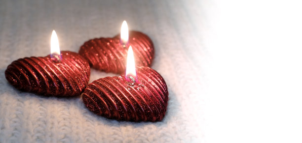 温馨温馨的情人节。三支红烛燃烧，爱情温暖。横幅，由燃烧的蜡烛和针织元素组成。庆祝理念，浪漫之夜图片下载