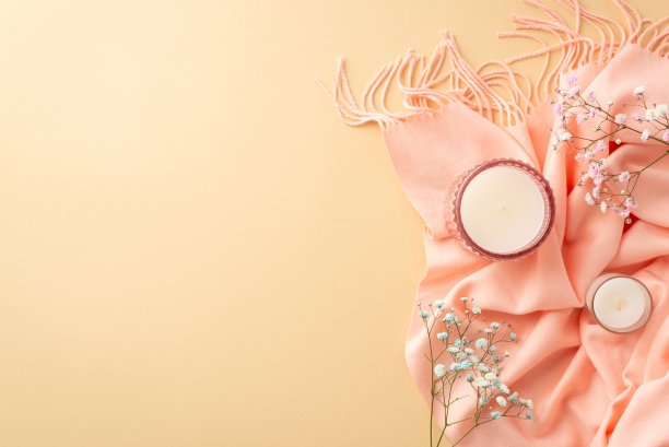 你好，春天概念。顶部视图照片蜡烛在玻璃持有人粉红色围巾和吉普赛人花在孤立的粉彩米色背景与复制空间图片下载