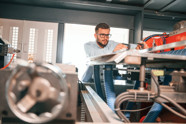 板材切割机。操作设备。穿着白色衣服的印刷厂工人在室内图片下载