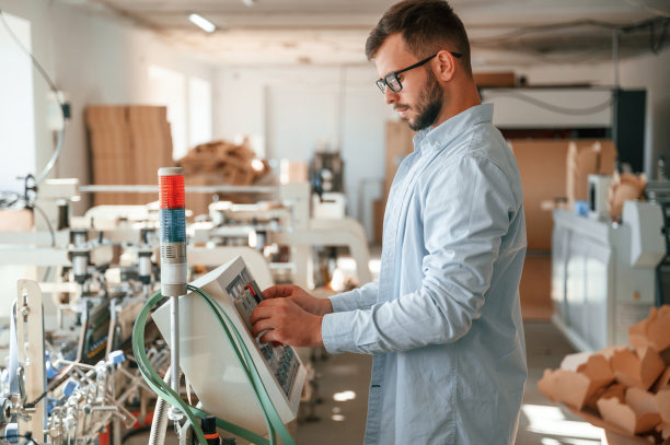 机器操作员正忙着安装设备。穿着白色衣服的印刷厂工人在室内图片下载