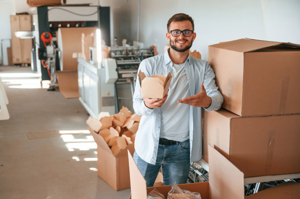 手持并展示木板。穿着白色衣服的印刷厂工人在室内图片下载