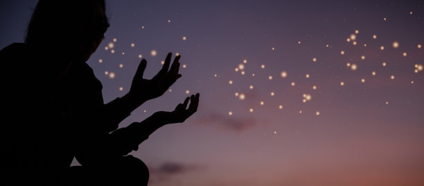 信仰基督教旗帜与基督教崇拜理念。精神祈祷手在太阳照耀下模糊了美丽的日落背景。日落时分，女人满怀希望地向上帝祈祷。图片下载