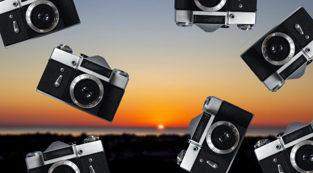 复古相机在一个模糊的背景背景的海上日落的背景。照片相机创意概念背景。旅游，度假和摄影概念图片下载