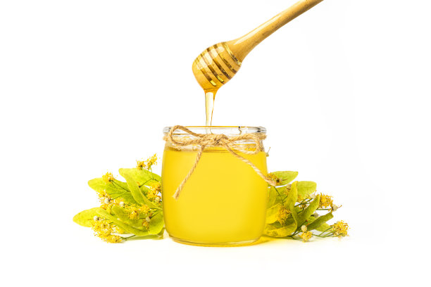 孤立的蜜蜂在玻璃罐和蜂蜜勺在白色背景图片下载