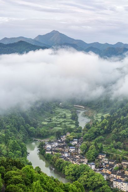 美丽的乡村风景在一个山谷，一个小村庄被雾覆盖，中国图片下载