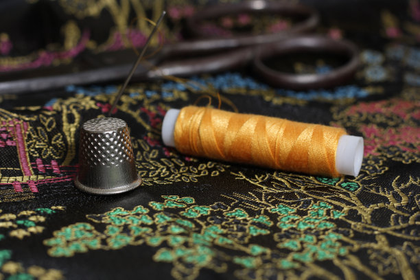 黄色线和顶针在Vintage中国黑丝绸图片下载