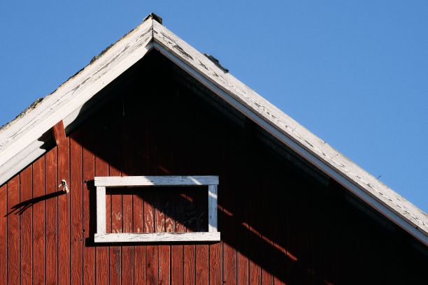 十月下旬，挪威托滕市斯克雷亚，红色的乡村木屋屋顶映衬着万里无云的蓝天图片下载